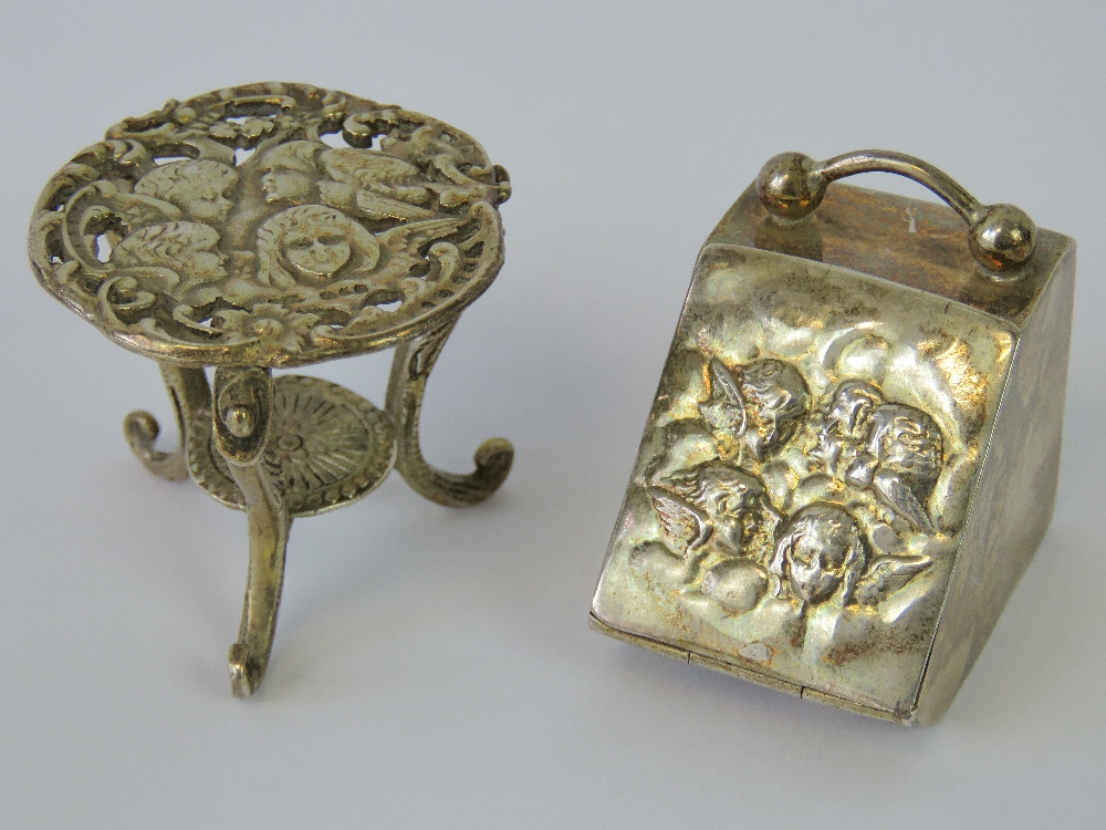 A HM silver dolls house table with depiction of cherubs to the table top, London hallmark, 0.