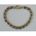 A 9ct yellow and white gold double flattened curb link bracelet, hallmarked 375. Weighing 21.93g.