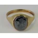 A 9ct gold signet ring set with carved hematite plaque, hallmarked 375, size T-U, 3.9g.