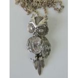 A silver articulated owl pendant with oval white stone chest, stamped 925, 6cm long,