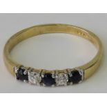 A 9ct gold sapphire and white stone ring, three sapphires separated by two white stones,