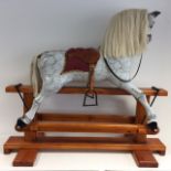 A full size dapple-grey late 20thC cantilever rocking horse with glass eyes and hand-painted