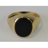 A 9ct gold signet ring with uncarved onyx oval plaque, hallmarked 375, size U, 5.