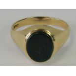 A 9ct gold signet ring with uncarved bloodstone oval plaque, hallmarked 375, size V, 4.