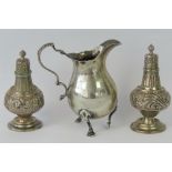 A HM silver cream jug, Birmingham 1920, and a pair of HM silver pepperettes, Birmingham 1911.