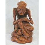 A carved bamboo figure of an ascetic Luohan; seated with emaciated arms and rested upon his knees,