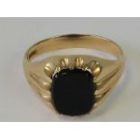 A 9ct gold signet ring with uncarved onyx oval plaque, hallmarked 375, size V, 4.