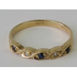 A 9ct gold diamond and sapphire ring, the sapphires and two diamonds in a twisted pattern,