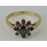 A 9ct gold and sapphire daisy cluster ring, central oval sapphire approx 0.