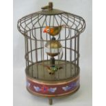 A brass bird cage clock with moving bird inside, 20cm.