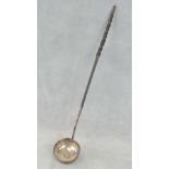 A white metal toddy ladle with twisted whale bone handle.