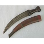 An early 20th century, Turkish Jambiya and sheath, the dagger has a carved hardwood hilt (a/f),