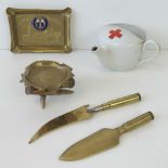 A Three pieces of WWI Trench Art including to bullet casing letter openers also a ceramic Red Cross