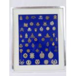 A montage of fifty various British regimental cap badges, framed and mounted, 54 x 40cm.