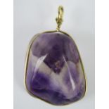 An uncarved amethyst pendant, silver wir