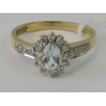 A 9ct gold aquamarine and diamond ring, central oval aquamarine surrounded by a gallery of diamonds,