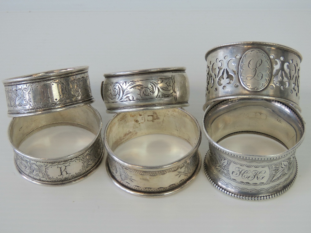 Six HM silver napkin rings; one pair and one with applied enameled shield, total weight 2.3ozt.