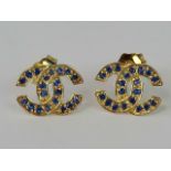 A pair of 10ct gold Chanel style interlocking C earrings, set with sapphires,