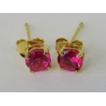 A pair of 10ct gold and round cut ruby stud earrings, stamped 10k, complete with butterfly backs, 0.