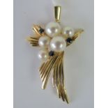 A 14ct gold, pearl and sapphire pendant, cluster of five pearls with three claw set sapphires,