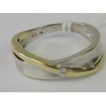 A 9ct white and yellow gold crossover style ring set with single round cut brilliant diamond,