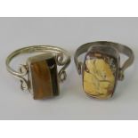 A silver ring set agate cabachon, size O and a white metal ring set with tigers eye cabachon,