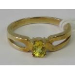 A 9ct gold crossover style ring set with an oval cut canary yellow stone, hallmarked 375, size M-N,