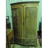 An unusual bow fronted solid flame mahogany doored wardrobe having twin drawers under, 120cm wide,