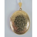 A 9ct gold oval locket with floral engraving, hallmarked 375, 4.5cm in length including bale, 9.