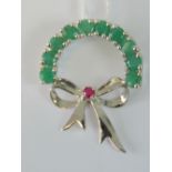 A silver half wreath and bow pendant set with round cut ruby and green gemstones, stamped 925, 3.