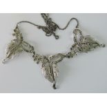 A silver and marcasite three panel necklace, each panel in the form of a leaf and flower,