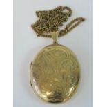 A large oval 9ct gold locket with floral engraving, hallmarked 375, 4.