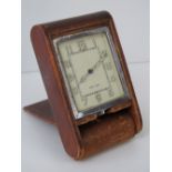 A vintage Le Coultre travel clock in leather case; 10cm long.