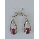 A pair of silver and ruby earrings,