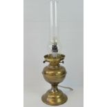 A Victorian brass oil lamp with replacement chimney; wired for electricity; 49cm high.