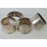 Four silver napkin rings a pair marked Stirling, a single ring marked Sterling,