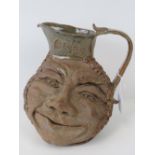 A mid 20th century large pottery grotesque face, cider jug; in the style of the Martin Brothers.