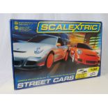 A boxes Scalextric 'Street Cars' set complete with 15ft track and two Porsche 997 race cars,