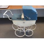 A vintage Silver Cross dolls pram with a retro plasticised doll.