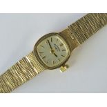 A 9ct gold Rotary ladies manual wind wristwatch on intergral 9ct gold bark effect strap,