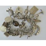 A HM silver charm bracelet with twenty-four charms attached including; 835 silver turtle,