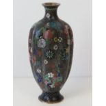 A fine quality cloisonné ribbed vase profusely decorated with flowers throughout. 18cm high.