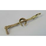 A 9ct gold riding crop and horseshoe stock pin brooch, stamped 9ct gold, 4.6cm long, 1.25g.