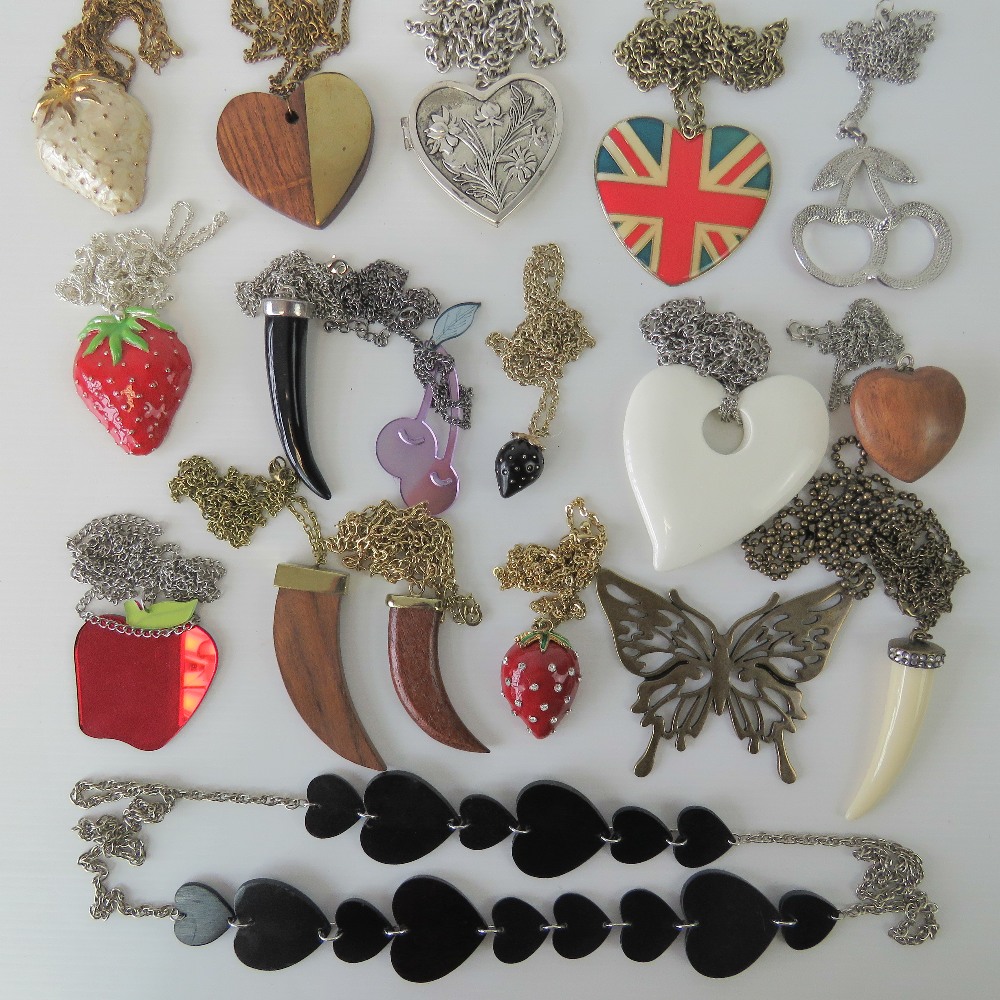 A quantity of costume jewellery necklaces including heart, claw, and fruit designs.