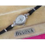 A ladies rolled white gold and diamond Bulova mechanical Swiss wristwatch in original Bulova pink