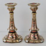 A pair of Royal Crown Derby Old Imari pattern, candlesticks; 16cm high; old repair to one a/f.