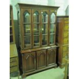 A contemporary mahogany glazed double door display cabinet, raised over base with three solid doors,