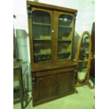 A Victorian glazed bookcase having two doors over and two solid doors under,