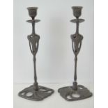 A pair of Art Nouveau bronzede metal candlesticks, each 28cm high.