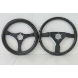 Two MOMO leather bound racing car steering wheels, measuring 37cm and 35cm dia respectively.